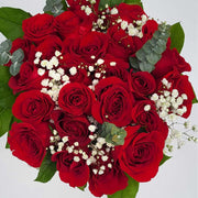 Two dozen imported, long-stemmed red roses nestled amidst seasonal greenery and elegant filler flowers.