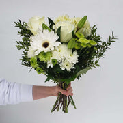 White flowers like rose, gerbera, hydrangea, lily and mums are accented with green flowers and seasonal greenery.