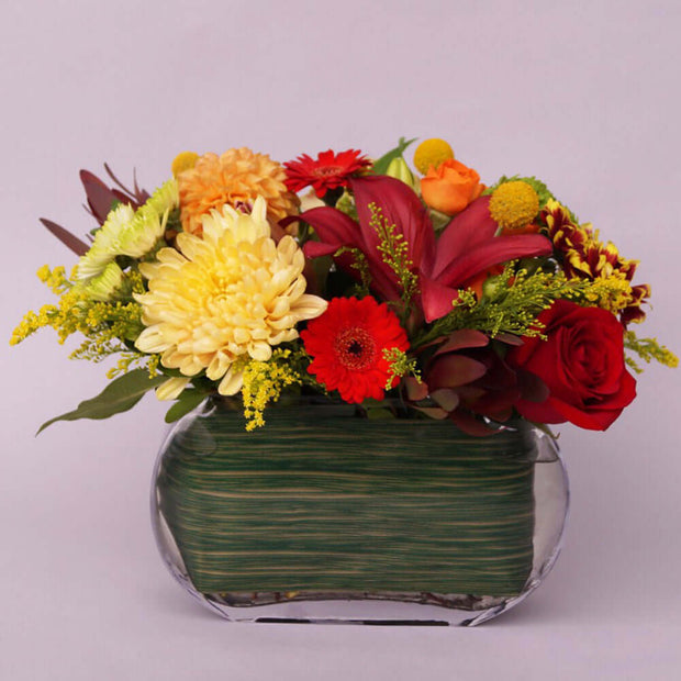 Medium tall vase arrangement filled with seasonal flowers