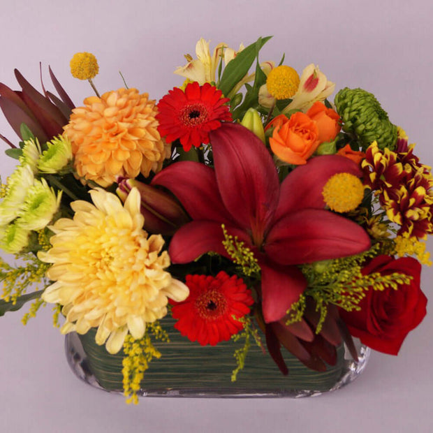 Medium tall vase arrangement filled with seasonal flowers
