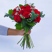 Dozen red roses in a hand-tied bouquet with filler flowers surrounded with seasonal greenery. The perfect gift to say "I love you". Our roses are of the highest quality, long stemmed and imported from Colombia and Ecuador.