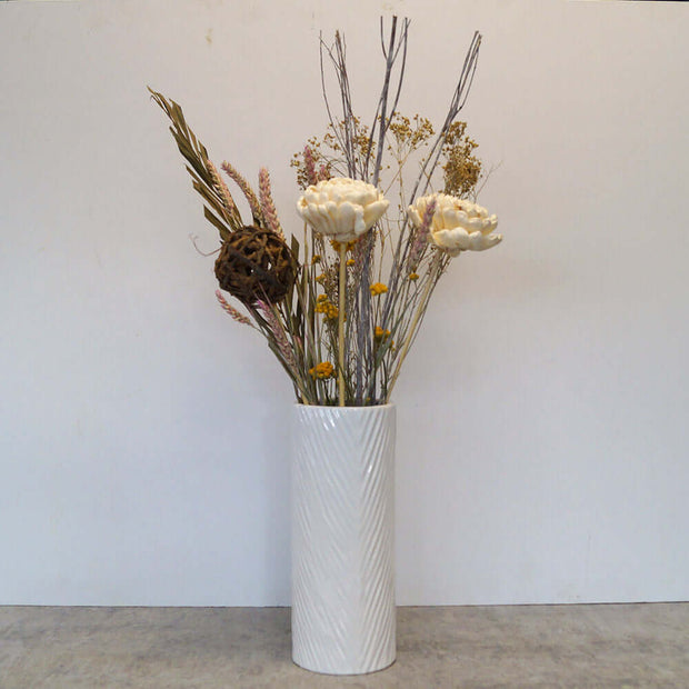 Dried flowers in white and neutral colors in a tall white vase. Perfect match for any decoration.
