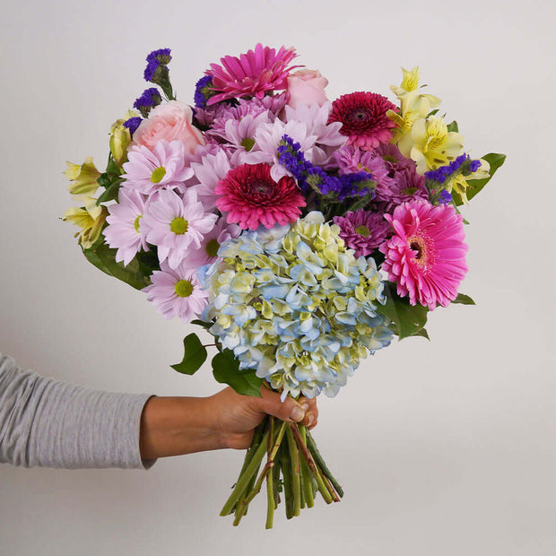 Seasonal and fresh flowers are selected and boast a winning combination of pink, purple and white hues.  This beautiful bouquet is excellent to celebrate a birthday, anniversary, or the birth of a new baby girl or express your thank you or get well wishes.