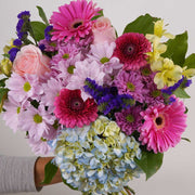 Seasonal and fresh flowers are selected and boast a winning combination of pink, purple and white hues.  This beautiful bouquet is excellent to celebrate a birthday, anniversary, or the birth of a new baby girl or express your thank you or get well wishes.