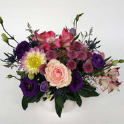 Perfect for those who love pink and purple, this stunning arrangement is set in an elegant white ceramic pumpkin